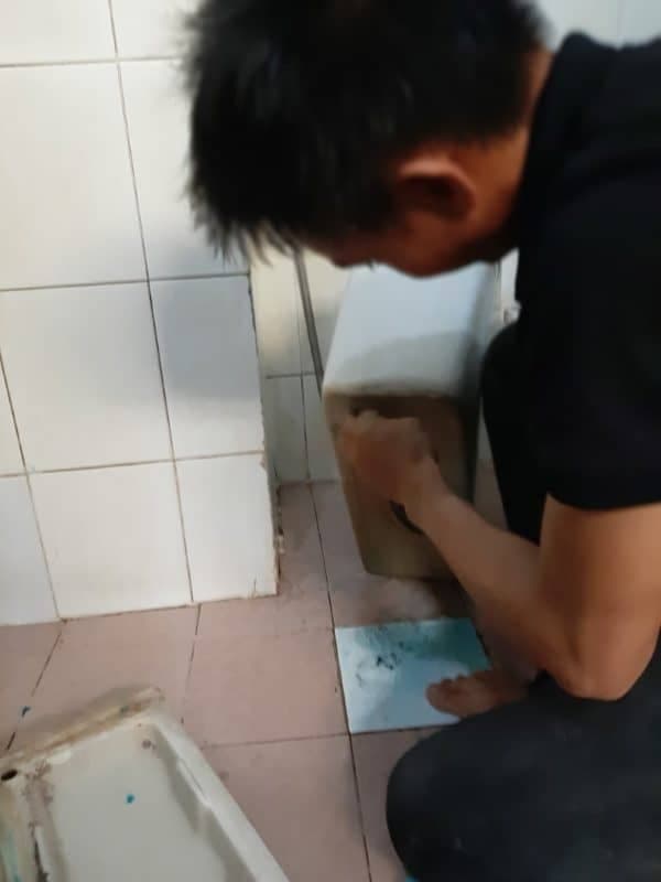 Cận cảnh việc cắt ốc để tháo bộ xả cũ một cách an toàn.