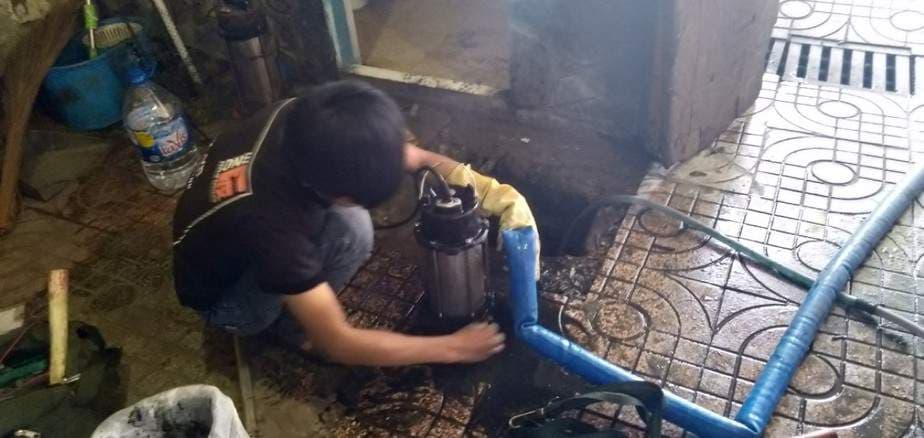 Thợ kỹ thuật đang kiểm tra và sửa chữa một máy bơm chìm bị hỏng.