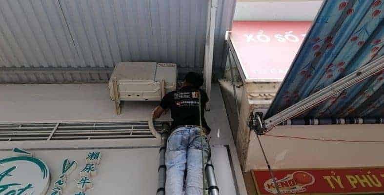 Kỹ thuật viên 1Fix cẩn thận vệ sinh dàn lạnh máy lạnh tại nhà khách ở Quận 12.