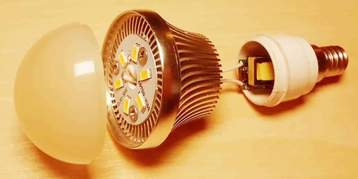 Tháo vỏ nhựa của một bóng đèn LED tròn để lộ bảng mạch bên trong.