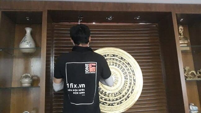 Thợ điện đang thay bóng đèn LED âm trần trong nhà.