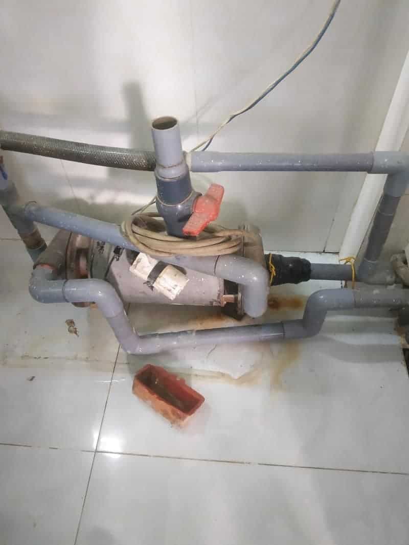 Thợ 1Fix đang kiểm tra và sửa máy bơm nước tại nhà khách hàng ở Quận 6.