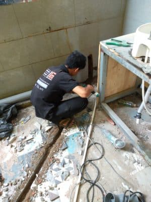 Thợ 1Fix đang thông nghẹt máng xối bị tắc do rác và lá cây.