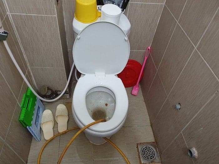 Thợ 1Fix kiểm tra và sửa chữa bồn cầu rò rỉ nước tại một gia đình ở Quận 1.