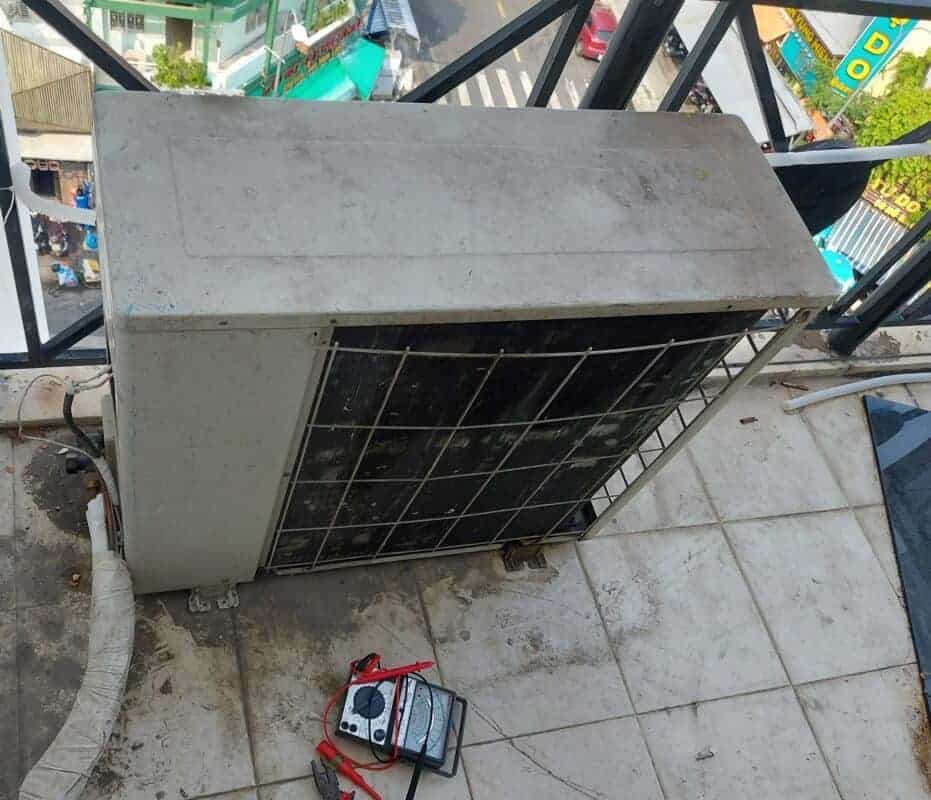 Thợ điện lạnh đang kiểm tra cục nóng, nơi có thể phát hiện các vấn đề về gas.