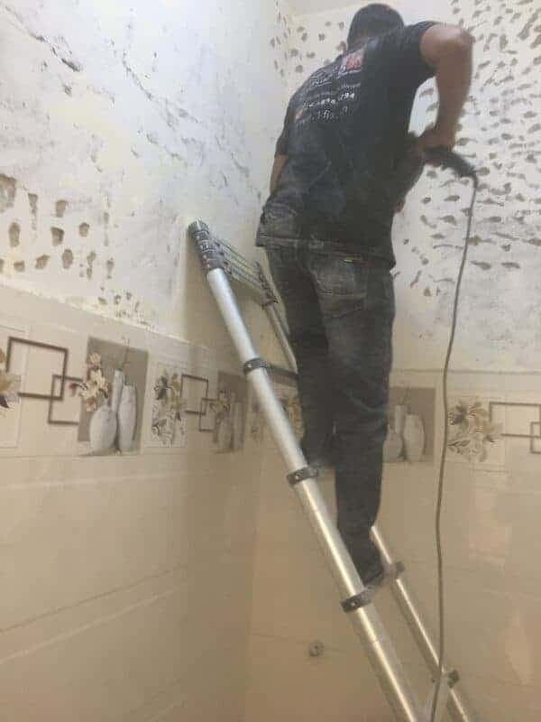 Thợ sơn 1Fix đang tỉ mỉ sơn lại phần tường ngoại thất của một tòa nhà tại Quận 1.