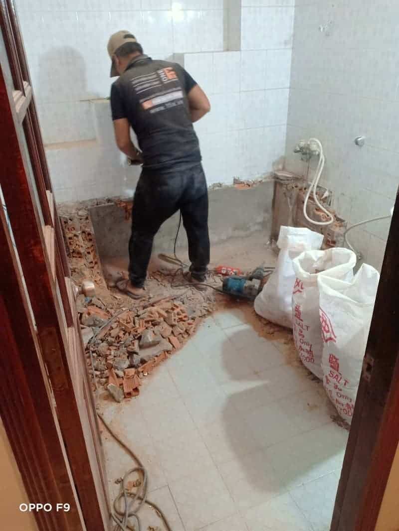 Thợ 1Fix đang khảo sát tình trạng tường nhà bị thấm nước nghiêm trọng tại một công trình ở Quận 6.