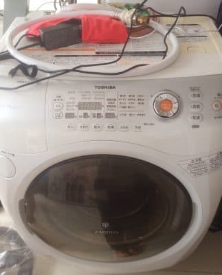 Nước rò rỉ từ phía sau máy giặt do lỏng ống cấp nước.