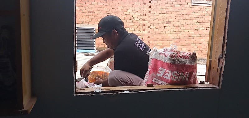 Thợ đang thi công lát gạch chống thấm trên bề mặt sân thượng đã được xử lý chống thấm lót.