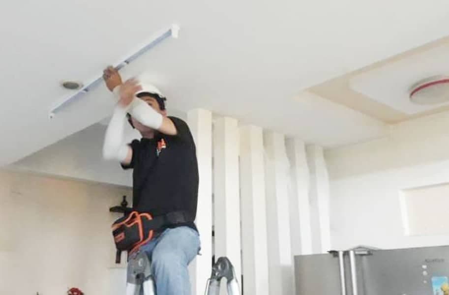 Tháo bóng đèn huỳnh quang cũ một cách cẩn thận để chuẩn bị nâng cấp lên đèn LED.