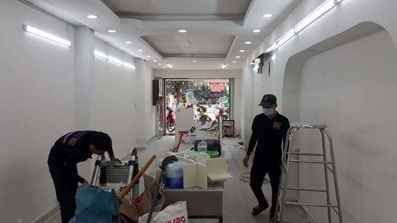Thợ 1Fix đang thi công lắp đặt hệ thống đèn rọi ray cho một cửa hàng thời trang tại TPHCM.