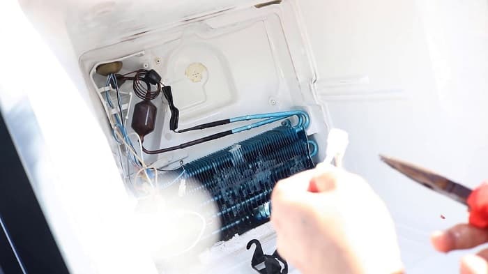 Thợ của 1Fix đang sử dụng đồng hồ chuyên dụng để kiểm tra các linh kiện bên trong tủ lạnh tại nhà khách hàng ở TPHCM.