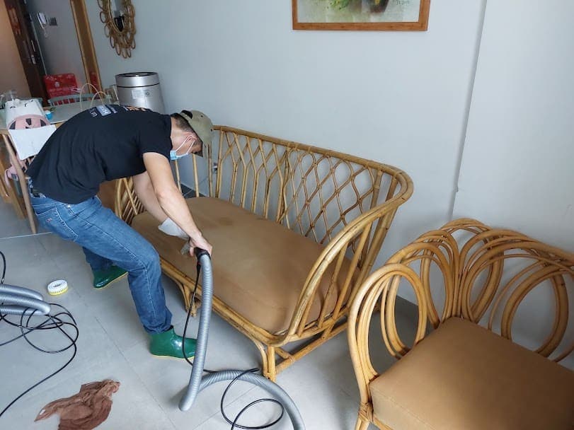 Thợ 1Fix đang sử dụng máy hút bụi chuyên dụng để làm sạch bề mặt sofa tại một căn hộ ở Quận 3.
