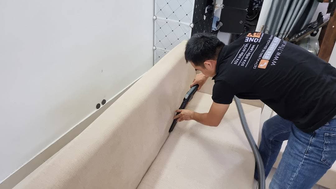 Thợ 1Fix đang sử dụng máy móc chuyên dụng để giặt ghế sofa tại nhà khách hàng ở Hóc Môn.