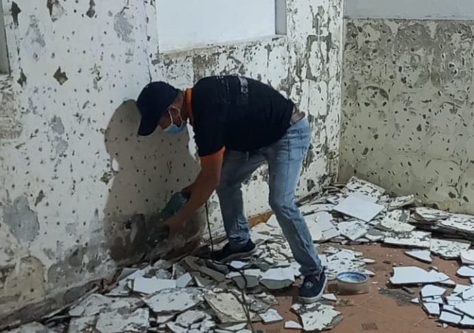 Thợ 1Fix đang tiến hành đo đạc và lắp đặt tấm ốp nhựa giả gỗ một cách cẩn thận.