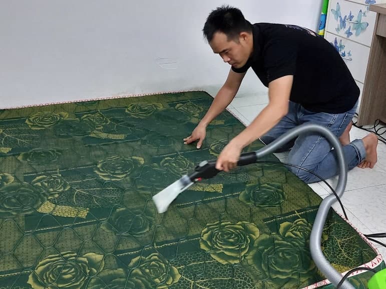 Cận cảnh máy giặt nệm phun hút đang làm sạch sâu các vết bẩn trên bề mặt nệm.