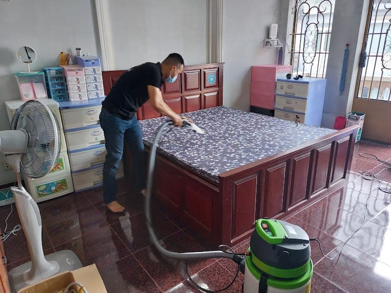 Kỹ thuật viên 1Fix sử dụng máy phun hút để giặt sạch sâu chiếc nệm tại Quận 6