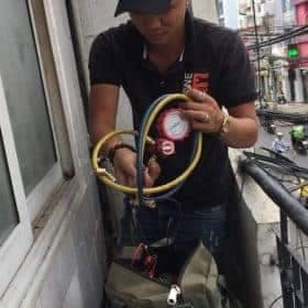 Kỹ thuật viên đang kết nối đồng hồ gas Value với dàn nóng máy lạnh để chuẩn bị hút chân không.