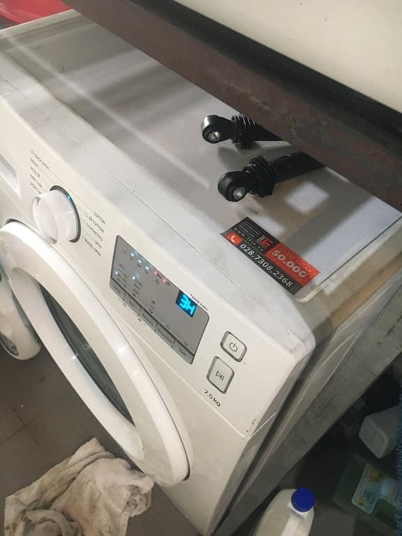 Cận cảnh kết nối ống thông hơi vào cửa thoát khí phía sau máy sấy.