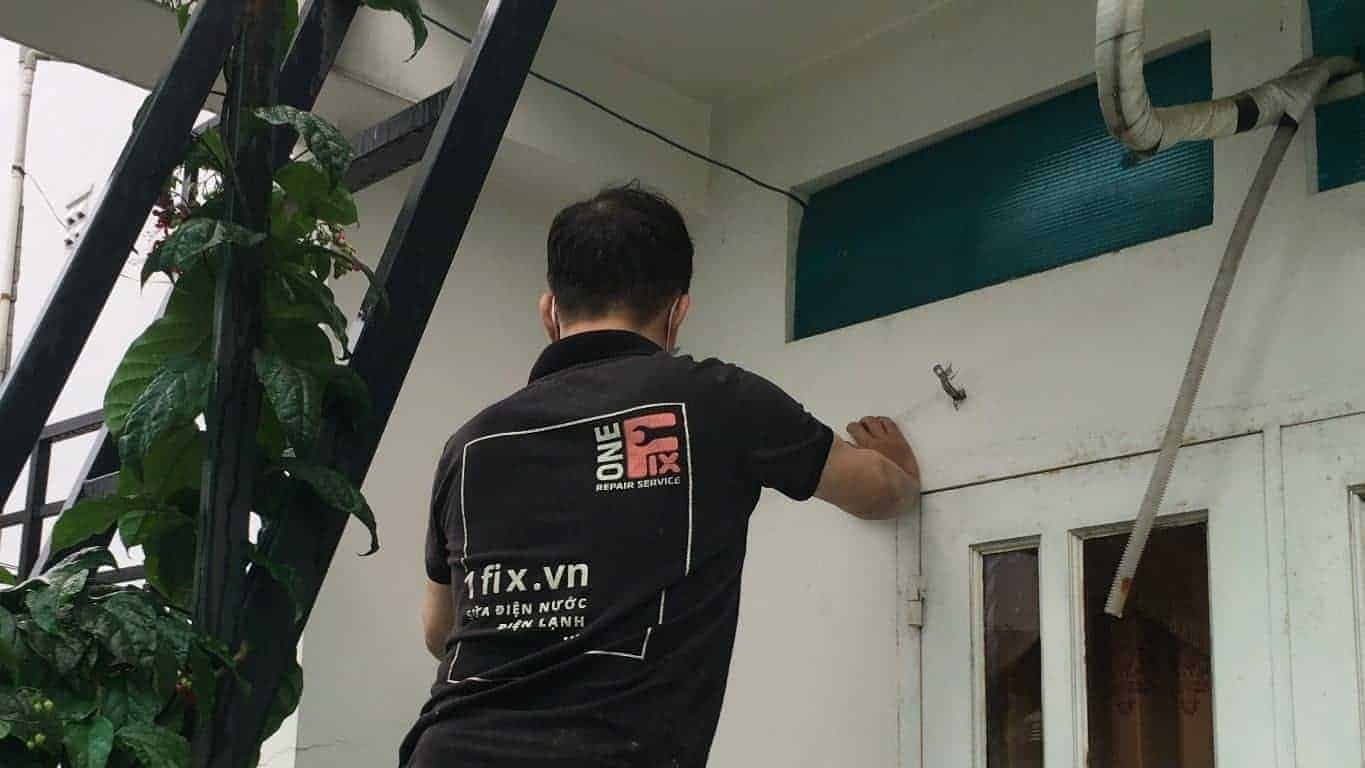Cận cảnh thợ 1Fix tinh chỉnh bản lề để khắc phục lỗi cửa nhôm kính bị xệ.