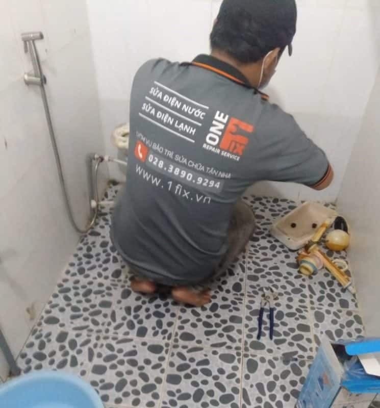 Thợ của 1Fix đang kiểm tra và sửa chữa bồn cầu không xả được nước tại một gia đình ở TPHCM.