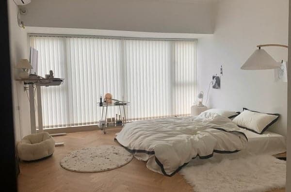 Trang trí phòng ngủ nhỏ không giường với nệm đặt sàn và tông màu đơn sắc.