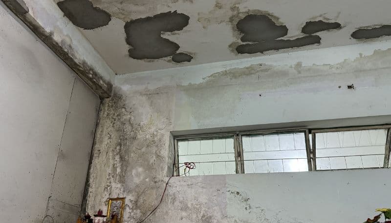 Thợ đang xử lý bề mặt tường chung cư cũ trước khi sơn.