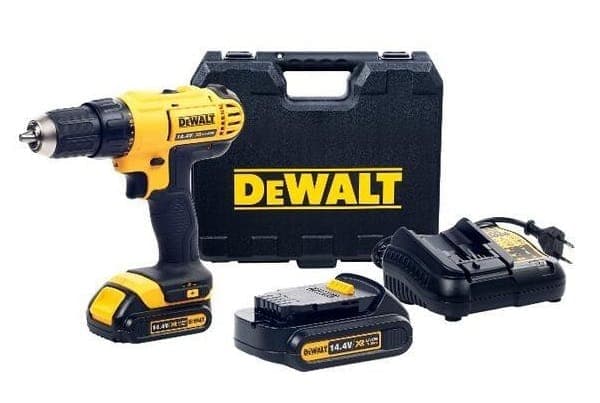 Thợ sửa chữa đang dùng máy khoan tường cầm tay dùng điện để lắp đặt một vật dụng lên tường.