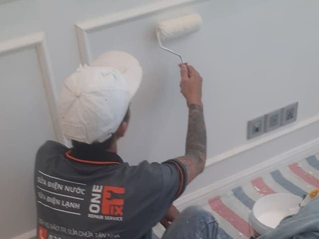 Thợ đang thi công lăn lớp sơn chống thấm lên bề mặt tường đã được xử lý.