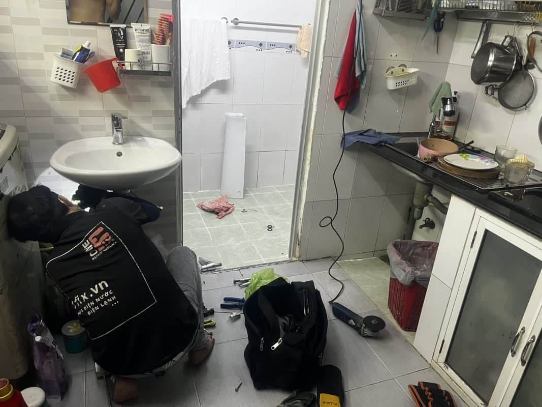 Thợ 1Fix đang tiến hành kiểm tra và thông tắc hệ thống xi phông bồn rửa mặt một cách chuyên nghiệp.