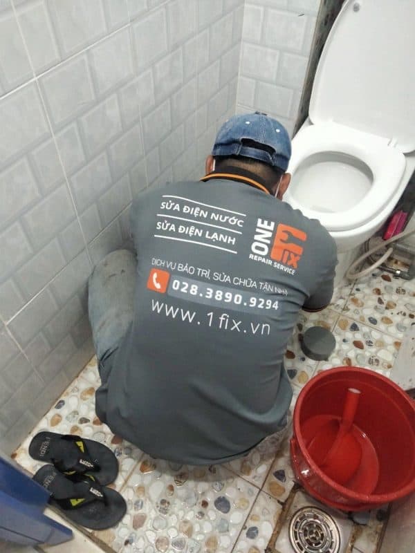 Thợ 1Fix đang tiến hành lắp đặt, chỉnh tâm bồn cầu cho khách hàng tại TPHCM.