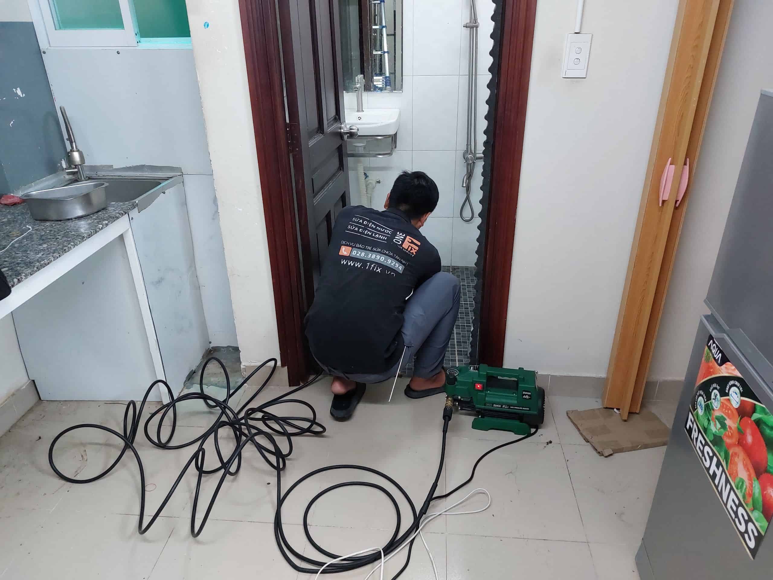 Thợ kỹ thuật của 1Fix đang kiểm tra và vệ sinh hệ thống máy nước nóng cho khách hàng.