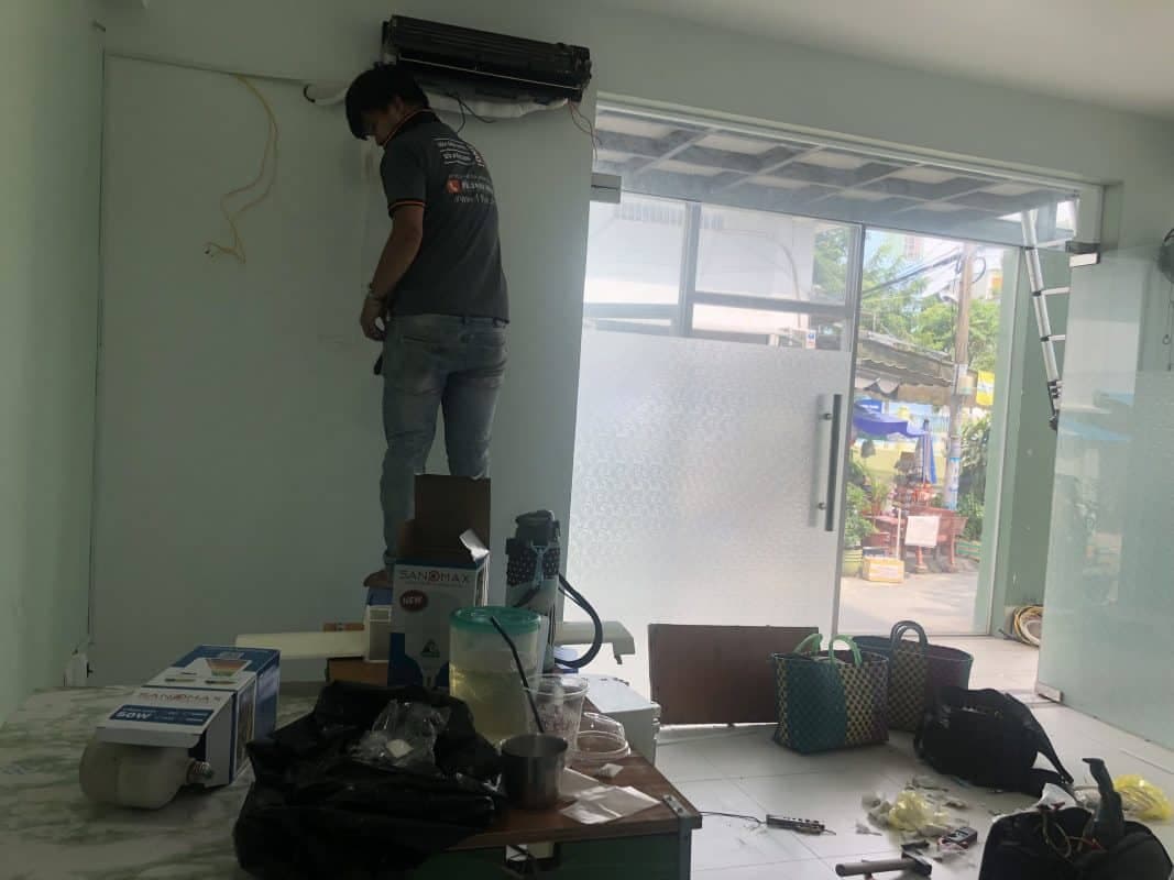 Thợ đang kiểm tra hệ thống dây điện phức tạp của máy lạnh bị rò điện.