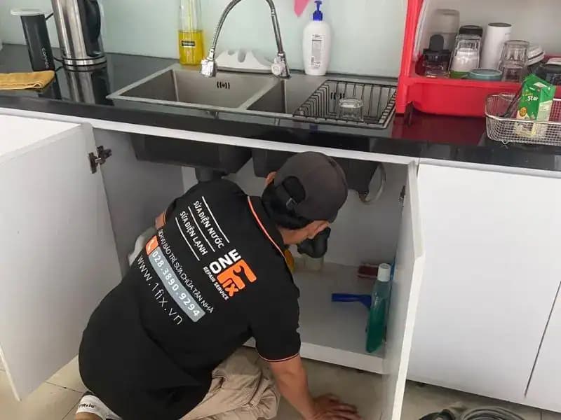 Hình ảnh cận cảnh các bộ phận của ống thoát nước chậu rửa bát đang được lắp ráp, cho thấy vị trí của gioăng cao su và đai ốc.