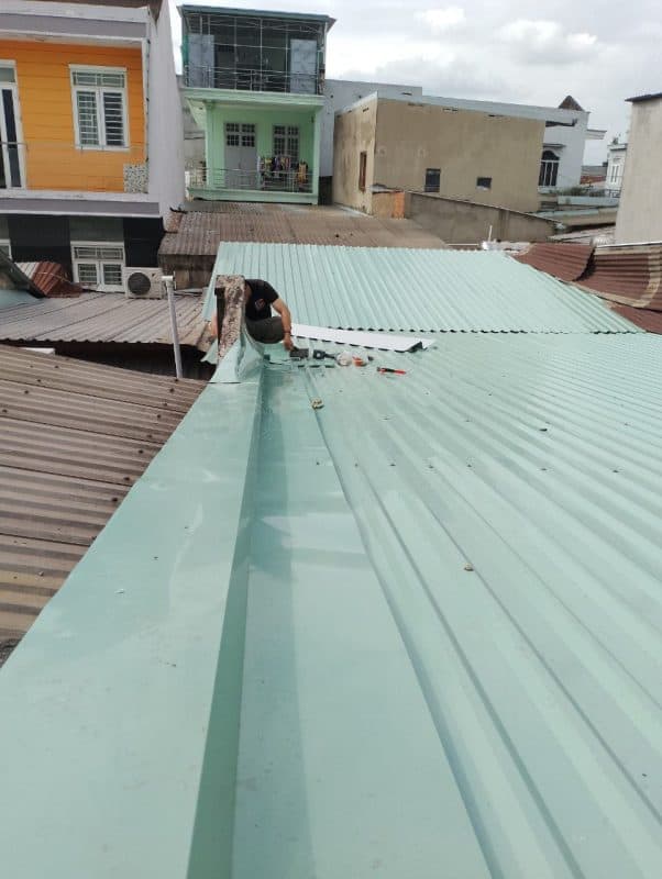 Thợ 1Fix đang lắp đặt giá đỡ và định vị máng thu nước trên mái ngói.