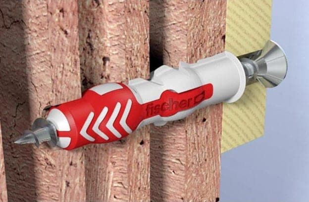 Đóng tắc kê nhựa vào lỗ khoan để đảm bảo vít bám chắc vào tường, tăng khả năng chịu lực.