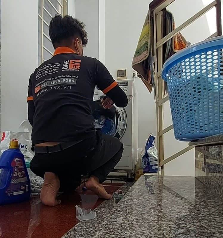 Kỹ thuật viên 1Fix đang kiểm tra bo mạch máy giặt bị lỗi chương trình tại nhà khách hàng TPHCM.