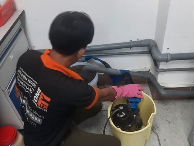 Thợ đang sử dụng thiết bị chuyên dụng để phát hiện đường ống nước bị rò rỉ dưới lòng đất.