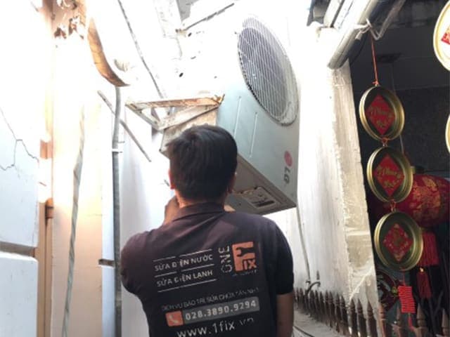 Kỹ thuật viên 1Fix kiểm tra dàn nóng điều hòa, nơi chứa block máy nén.