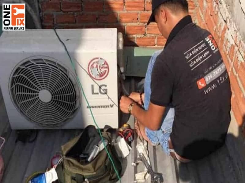 Thợ điện lạnh đang kiểm tra và hàn ống đồng tại dàn nóng máy lạnh.