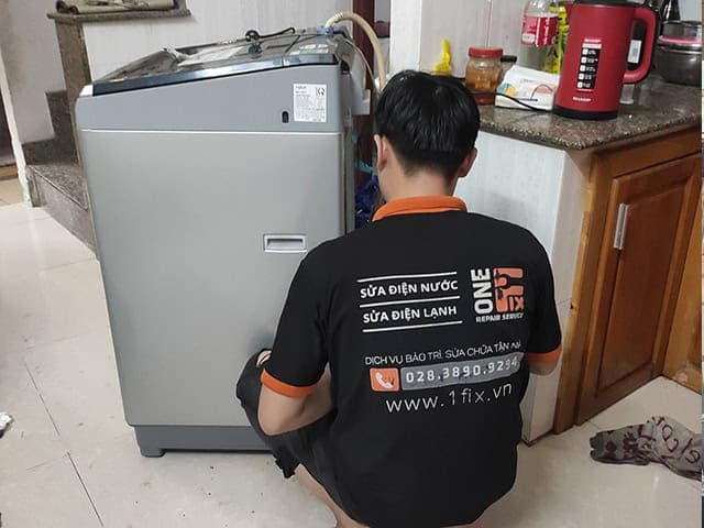 Một chiếc máy giặt LG cửa trên đang mở nắp, cho thấy lồng giặt bên trong.