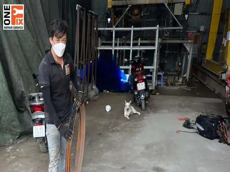 Thợ điện đang kiểm tra hệ thống dây điện phức tạp trong nhà xưởng, đảm bảo chất lượng và an toàn điện năng.