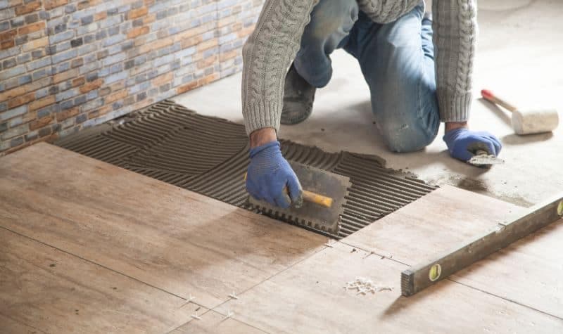 Thợ đang kiểm tra hiện trạng nền gạch cũ cần cải tạo