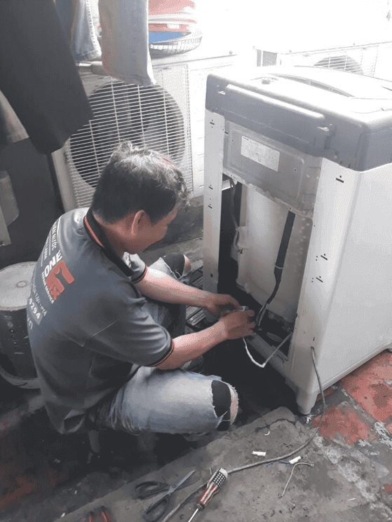 Thợ 1Fix đang kiểm tra và thay hộp số máy giặt chuyên nghiệp tại nhà khách hàng TPHCM.