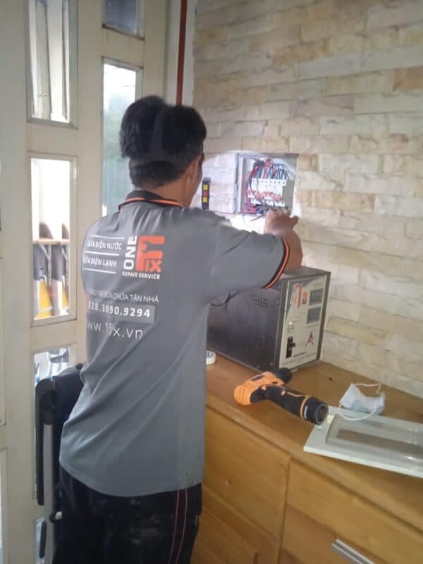 Thợ điện đang kiểm tra và lắp đặt aptomat chống giật RCBO cho bình nóng lạnh.