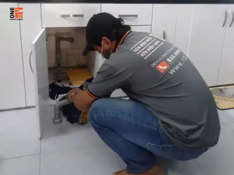 Thợ đang kiểm tra đường ống hút bị bẩn, một nguyên nhân phổ biến khiến máy bơm không lên nước.