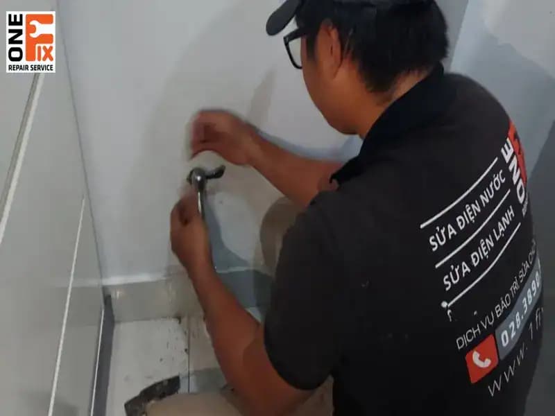 Một người thợ chuyên nghiệp đang dùng dụng cụ chuyên dụng để siết chặt lại khớp nối ống nước, đảm bảo không còn rò rỉ.