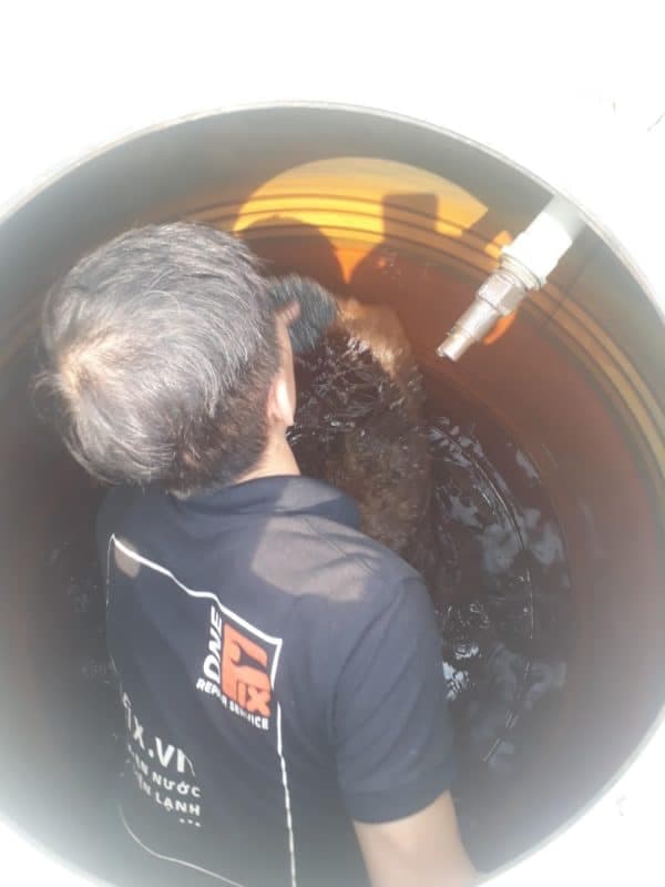 Thợ 1Fix đang thực hiện vệ sinh chuyên sâu cho bồn nước và hệ thống máy năng lượng mặt trời.