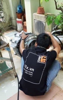 Thợ 1Fix đang vệ sinh bộ lọc cặn cho máy giặt cửa trước Electrolux tại quận Tân Phú.