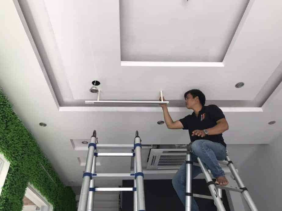 Thợ điện 1Fix đang lắp đặt hệ thống đèn chiếu sáng chuyên nghiệp cho một salon tóc tại TPHCM.